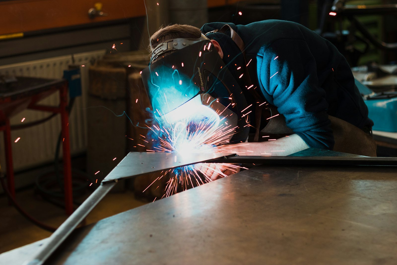 Welder working on stainless steel breather valve parts