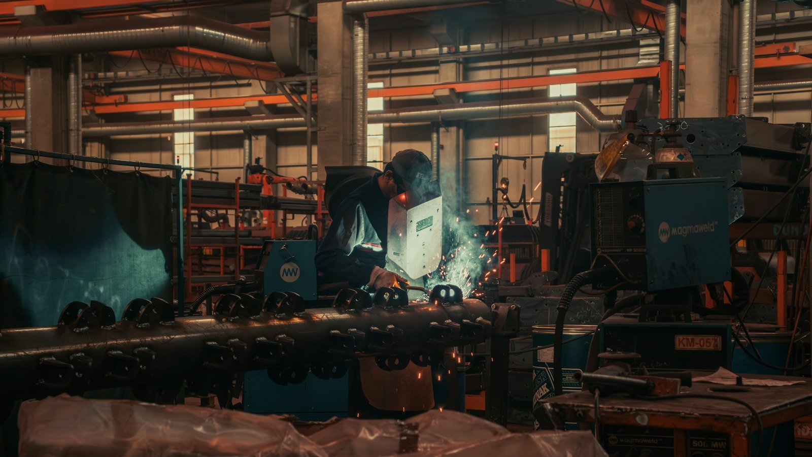 Factory worker welding stainless steel tees